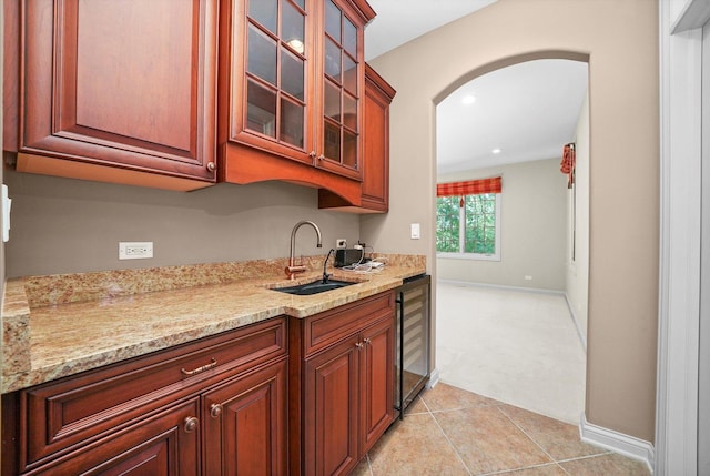 kitchen with sink, light stone countertops, wine cooler, and light tile patterned floors