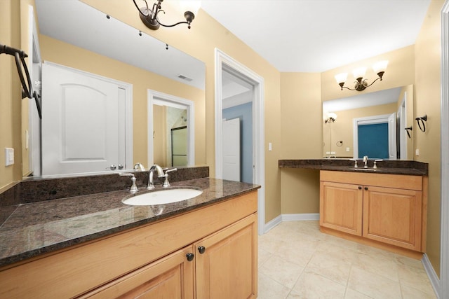 bathroom with tile patterned floors, vanity, and a chandelier