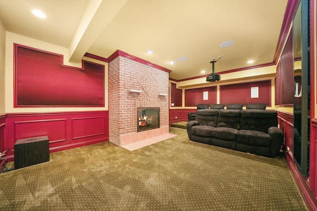 carpeted cinema with beam ceiling, crown molding, and a brick fireplace