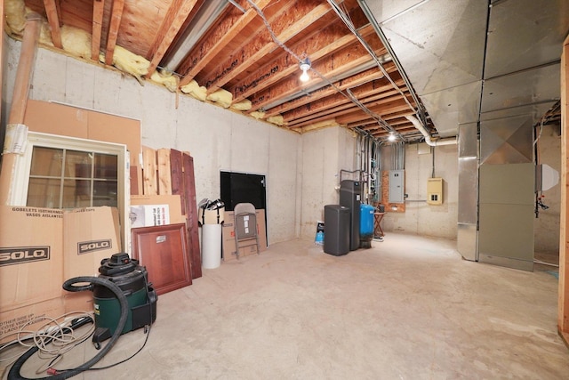 basement featuring electric panel and heating unit