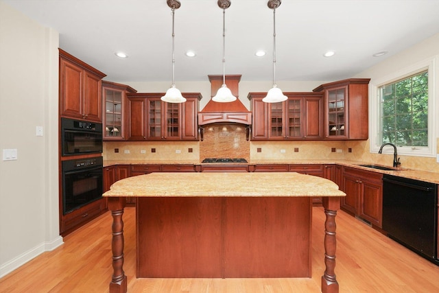 kitchen featuring sink, black appliances, a center island, and custom range hood