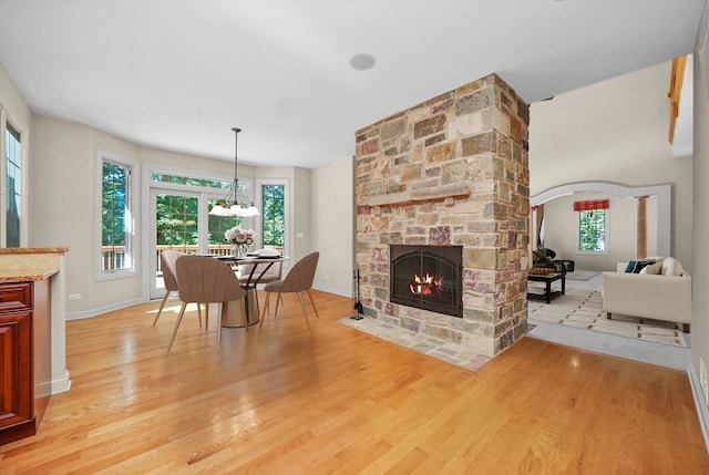 dining area with light hardwood / wood-style flooring, a wealth of natural light, and a fireplace