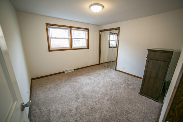 empty room with baseboards, visible vents, and light colored carpet