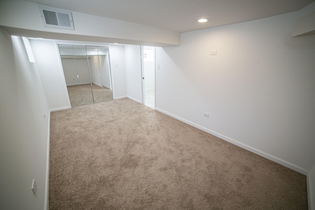 finished below grade area with light carpet, recessed lighting, visible vents, and baseboards