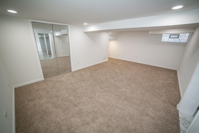 basement featuring carpet floors, baseboards, and recessed lighting