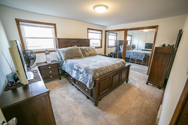 bedroom featuring multiple closets and light colored carpet