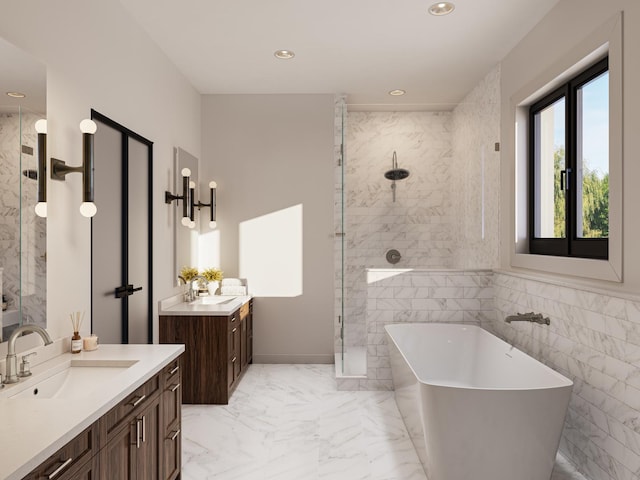 bathroom with tile walls, separate shower and tub, and vanity