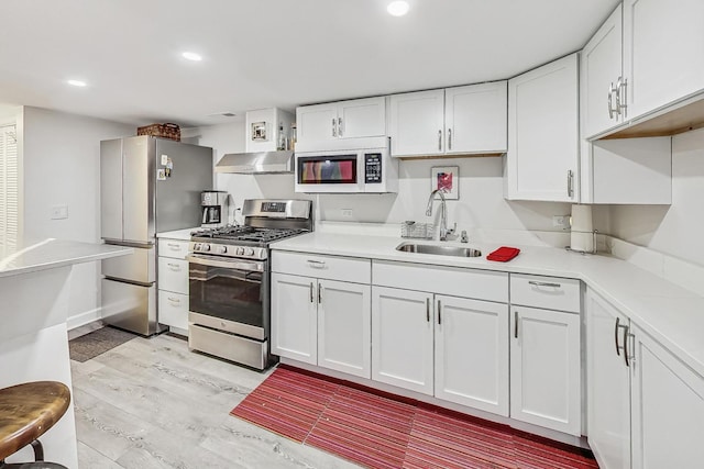 kitchen featuring white cabinetry, sink, stainless steel appliances, and light hardwood / wood-style floors