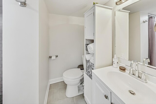 bathroom with vanity, toilet, tile patterned floors, and walk in shower