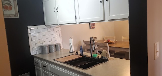 kitchen with white cabinetry, sink, and tasteful backsplash