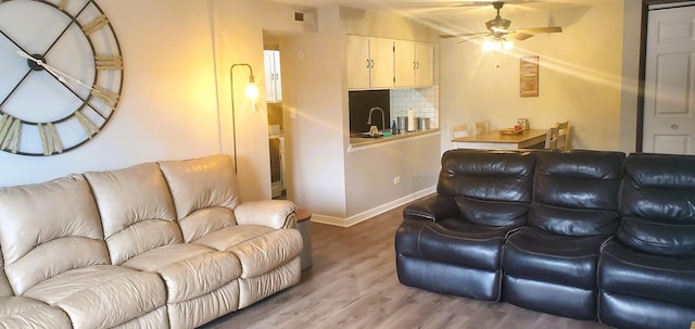 living room featuring sink, hardwood / wood-style floors, and ceiling fan