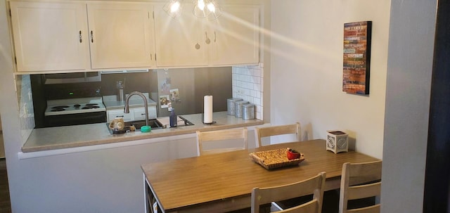 kitchen with white cabinetry, sink, black electric range oven, and backsplash