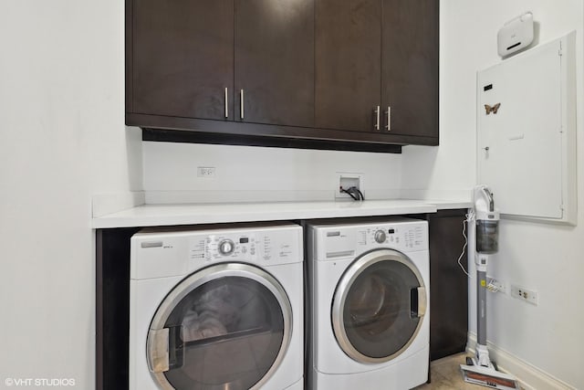 washroom featuring cabinet space, baseboards, and washer and dryer