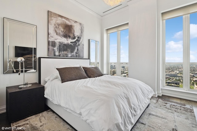 bedroom with multiple windows, wood finished floors, and crown molding