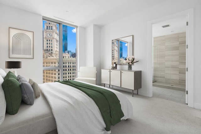 bedroom with light carpet, a wall of windows, and ensuite bathroom