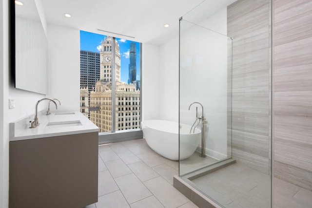 bathroom with vanity, a bath, and tile patterned floors