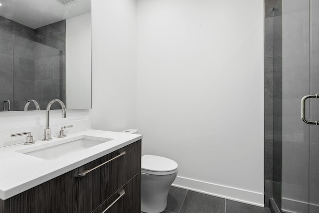 bathroom featuring toilet, vanity, and a shower with door