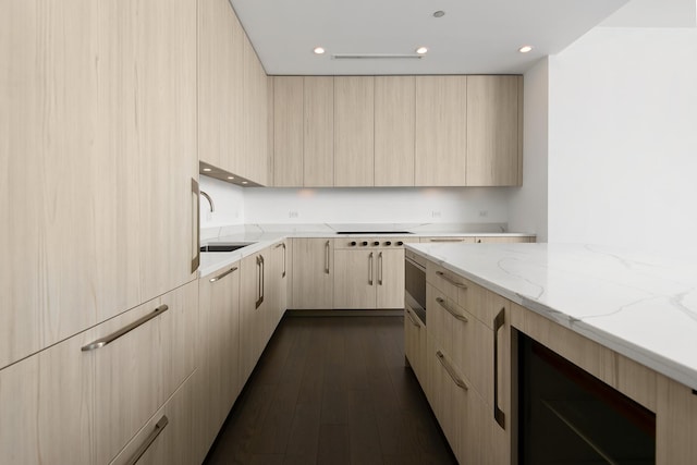 kitchen with sink, light stone counters, dark wood-type flooring, white stovetop, and light brown cabinets