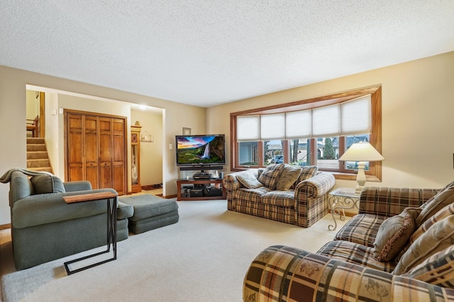 living area featuring baseboards, carpet flooring, stairway, and a textured ceiling