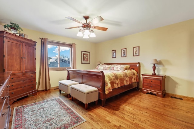 bedroom featuring light wood-style flooring, visible vents, and ceiling fan