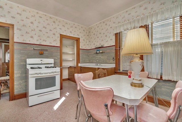 dining room with wainscoting, crown molding, and wallpapered walls