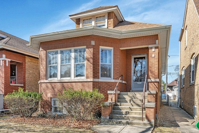 view of front of house featuring a gate, brick siding, a shingled roof, and fence