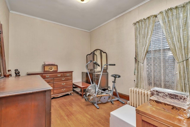 interior space with light wood-type flooring, radiator, and ornamental molding