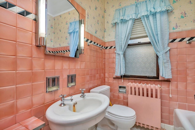 full bathroom with a bath, wallpapered walls, radiator heating unit, a sink, and toilet