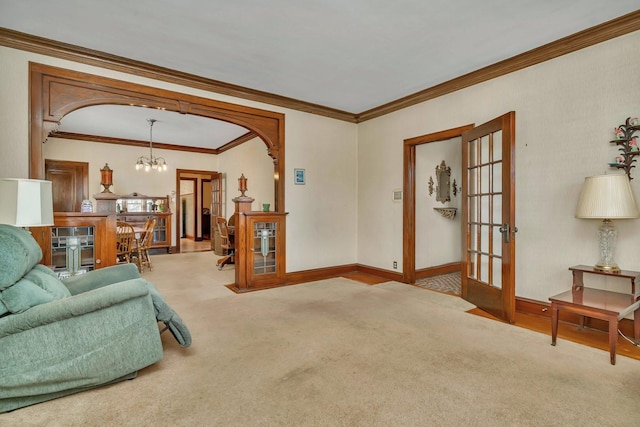 carpeted living room with arched walkways, a notable chandelier, french doors, and baseboards