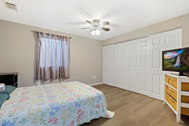 bedroom with ceiling fan, wood-type flooring, and a closet