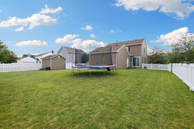 view of yard featuring a trampoline and a storage unit