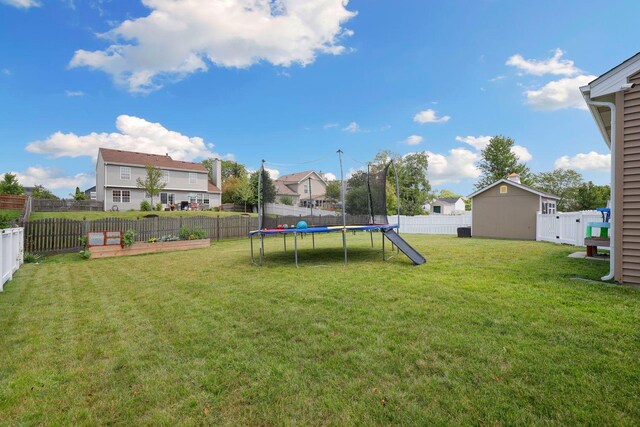 view of yard with a trampoline and a storage unit