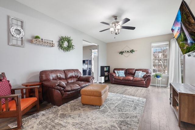 living room with light wood-type flooring and ceiling fan