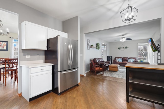 kitchen featuring light hardwood / wood-style floors, pendant lighting, white cabinetry, and stainless steel fridge