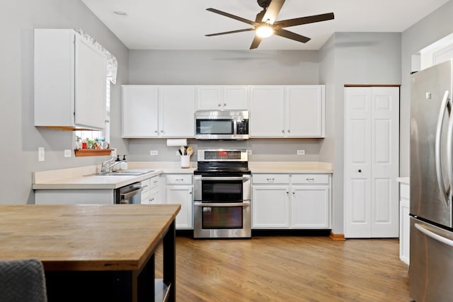 kitchen featuring light hardwood / wood-style floors, white cabinetry, stainless steel appliances, and sink