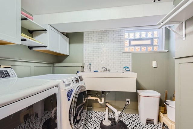 laundry room with cabinet space, washer and clothes dryer, and a sink