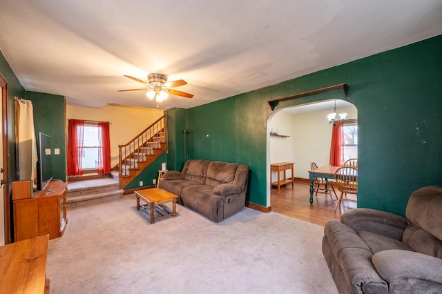 living room with carpet flooring and ceiling fan with notable chandelier