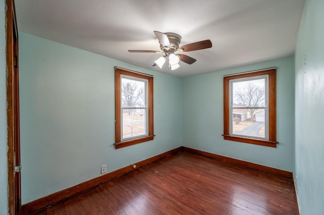 spare room featuring ceiling fan, dark wood-type flooring, and a wealth of natural light