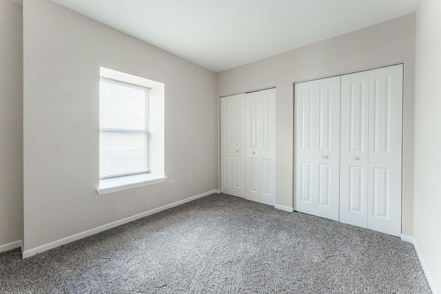 unfurnished bedroom with carpet and multiple closets