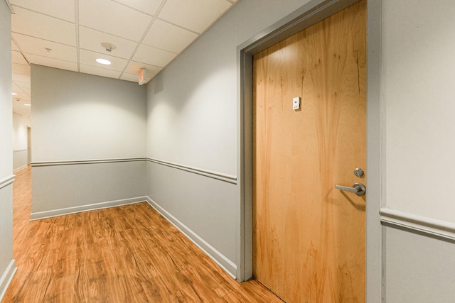 interior space featuring a drop ceiling and hardwood / wood-style floors