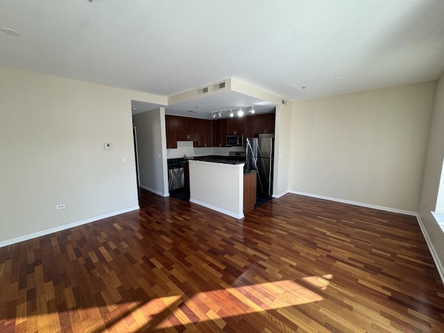 unfurnished living room featuring dark hardwood / wood-style flooring and rail lighting