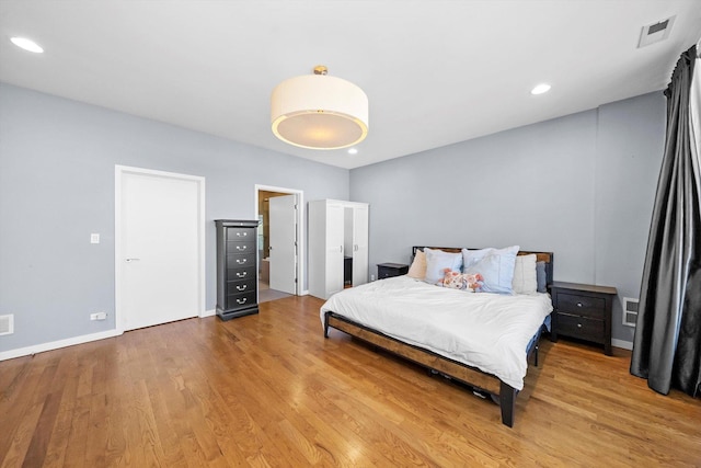 bedroom featuring recessed lighting, wood finished floors, visible vents, and baseboards