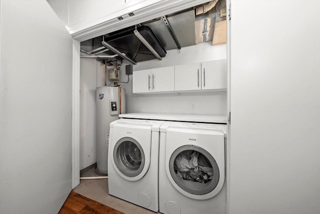 clothes washing area with electric water heater, wood finished floors, and washer and clothes dryer