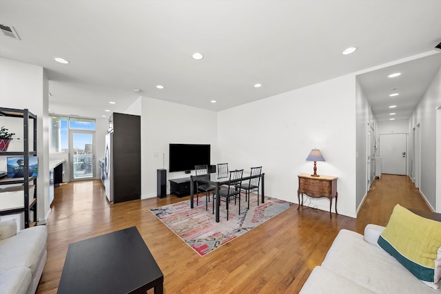 living area with recessed lighting, wood finished floors, and baseboards