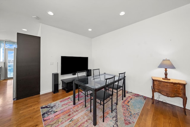 office with floor to ceiling windows, recessed lighting, baseboards, and wood finished floors