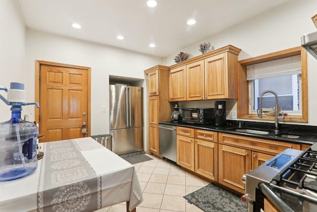 kitchen featuring light tile patterned flooring, stainless steel appliances, dark stone counters, and sink