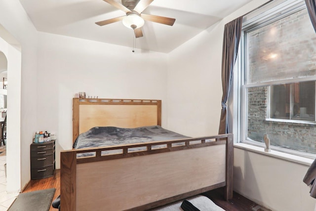 bedroom with ceiling fan, multiple windows, and wood-type flooring