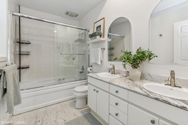 full bathroom with combined bath / shower with glass door, vanity, and toilet