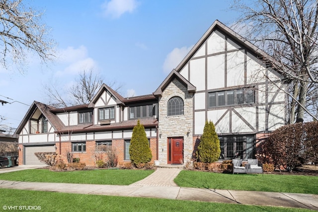 tudor home with brick siding, stucco siding, concrete driveway, stone siding, and a front lawn