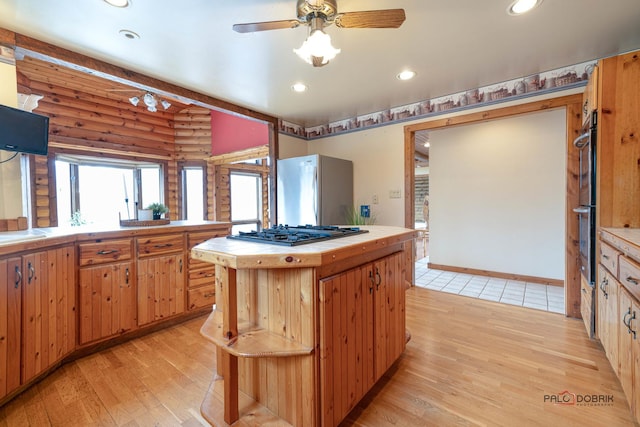 kitchen featuring appliances with stainless steel finishes, recessed lighting, rustic walls, and light wood-style flooring